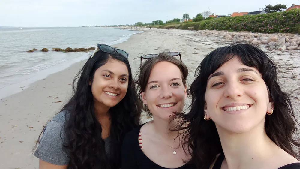 Three girls on a beach smiling