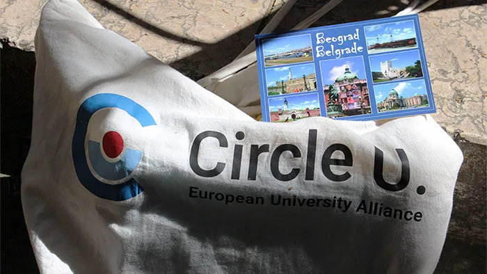 Tote bag with the Circle U. logo and a postcard from Belgrade
