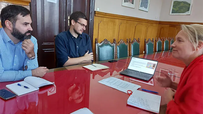 Three people at a table taking