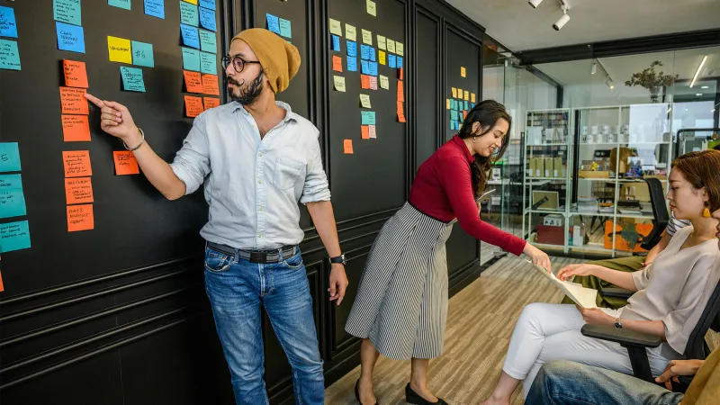 Picture by Pexels/Ketut Subiyanto of people in a workshop with post-it notes on a board