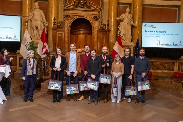 PhD candidates receiving a gift at the Circle U. 5th anniversary