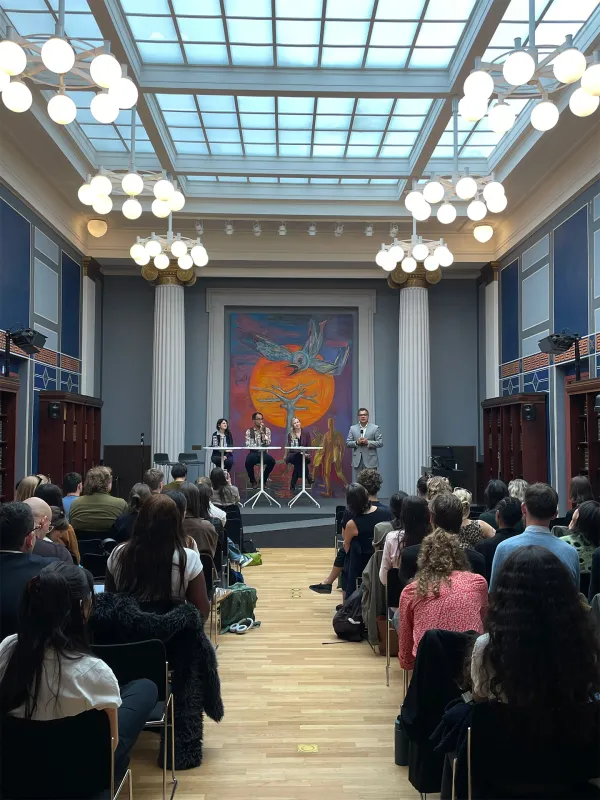 Four people on a stage in front of a seated audience