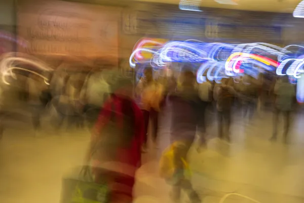 A blurry scene of people moving in an urban setting. 